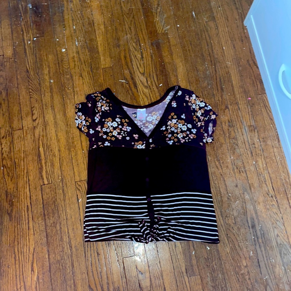 The size is medium and it is a flower shirt with purple and white.